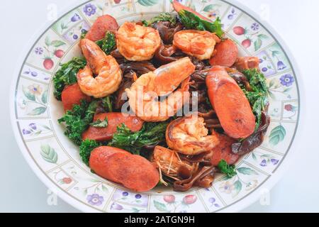 Mescolare piatto di noodle fritto con salsa di soia nera, gamberetti, Kale e salsicce. Cucina tailandese dalla cultura cinese. Foto Stock