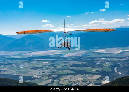 Deltaplano in azione. Sportivo estremale che gode il suo viaggio ricreativo a Creston, British Columbia, Canada. Scatto lungo Foto Stock