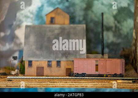 Foto macro di un carro ferroviario giocattolo e di una grande casa. La scena rurale realizzata con veri giocattoli in miniatura dal collezionista. Vista ravvicinata Foto Stock