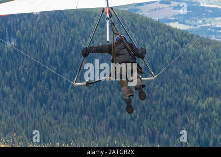 Vista ravvicinata dell'uomo aliante che vola in volo. Vista dal retro. Extremal sportivo godendo il suo week-end ricreativo. Foto Stock