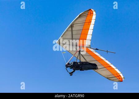 Hang Glider volare nel cielo in una giornata di sole. Attività ricreative durante le vacanze estive. Volo in volo di deltaplano Foto Stock