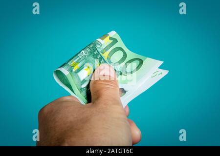 Primo piano di persona che sta raggiungendo un conto di cento euro. Foto Stock