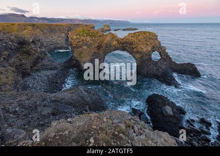 Gatklettur, Arch Rock una scogliera con un arco circolare, Arnarstapi, Islanda Foto Stock