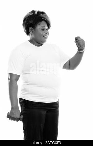 Profilo vista di felice grasso nero donna africana sorridente mentre alzando dumbbell pronto per la palestra Foto Stock