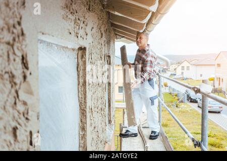 Cartongesso in piedi su impalcature in cantiere Foto Stock