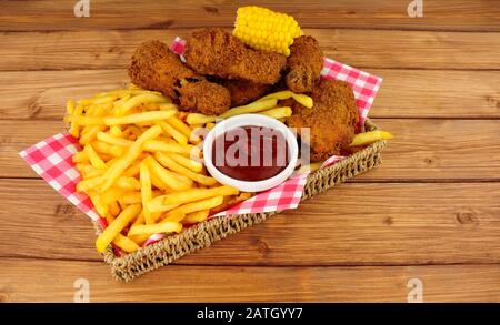 Pollo fritto del sud e patatine fritte pasto in un cestino su uno sfondo di legno Foto Stock