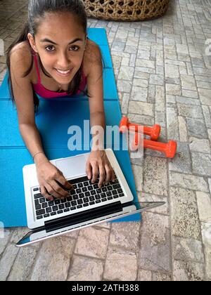 Ragazza latina che si allenano a casa con un computer portatile, Panama, America Centrale Foto Stock