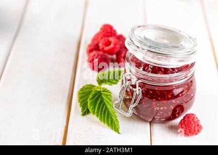 Marmellata di lamponi in vasetto di vetro, spazio di copia Foto Stock