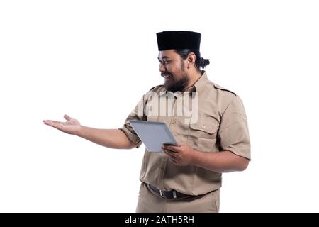 ritratto di lavoratore asiatico con uniforme marrone che si presenta per copiare spazio mentre tiene il pc tablet Foto Stock