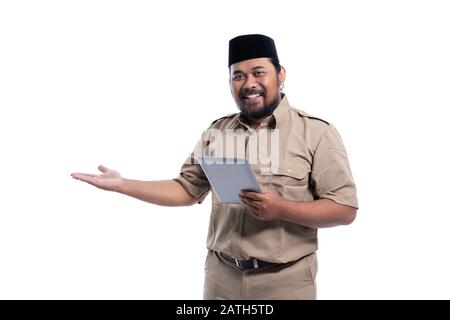 ritratto di lavoratore asiatico con uniforme marrone che si presenta per copiare spazio mentre tiene il pc tablet Foto Stock