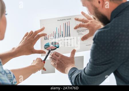 giovani dipendenti che puntano penna sul grafico finanziario Foto Stock