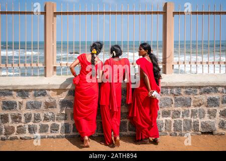 Tre pellegrini indù in rosso visitando Mahabalipuram vicino a Chenai. Da una serie di foto di viaggio nel sud dell'India. Data Della Foto: Martedì 7 Gennaio 2020. P Foto Stock