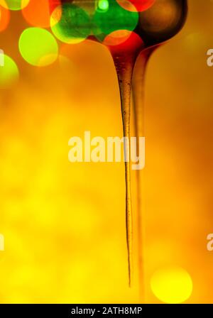 Schizzi di miele dolce biologico. Miele che si immerge dal cucchiaio di miele di legno Foto Stock