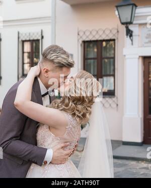 primo piano. felice sposa e sposo baciare in piedi sulla strada. Foto Stock