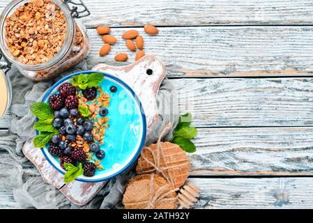 Blue Spirulina e Frutta Fresca Smoothie Bowl Con more, mirtilli, muesli e yogurt. Colazione. Vista dall'alto. Spazio libero per il testo. Foto Stock