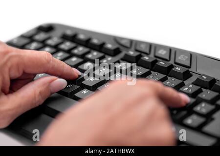 Le mani delle donne anziane con una caccia e una digitazione di beccare o brad sulla tastiera, digitando con le dita indice Foto Stock