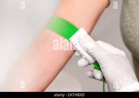 Paziente con una banda di laccio emostatico sul braccio, preparazione per il prelievo ematico, closeup Foto Stock