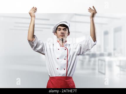 Giovane chef maschile con un cartello bianco vuoto Foto Stock