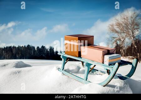 Regali su una slitta di cazzo shabby di fronte al paesaggio nevoso wintertime, concetto di natale Foto Stock