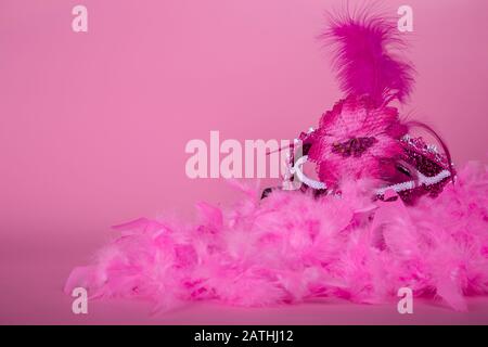 Maschera veneta fucsia su fondo rosa boa e fucsia. Foto Stock