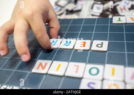 Pratiche del bambino con il gioco del bordo di formazione di parola. Il gioco è fatto con pezzi di lettera magnetica. Messa a fuoco selettiva Foto Stock