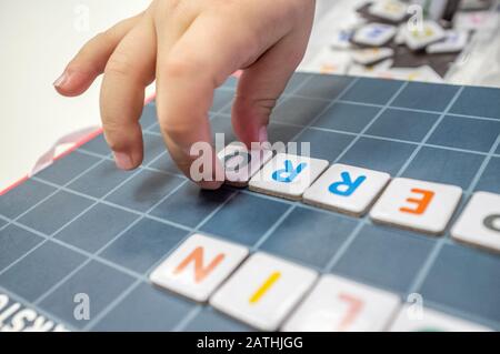 Pratiche del bambino con il gioco del bordo di formazione di parola. Il gioco è fatto con pezzi di lettera magnetica. Messa a fuoco selettiva Foto Stock