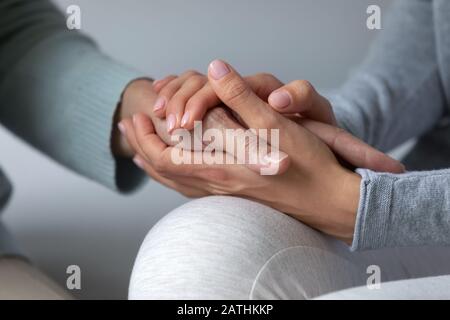 Amorevole madre e figlia tengono mani che hanno un momento vicino Foto Stock