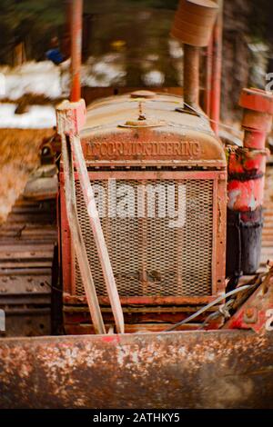 Un vecchio, rosso 1932 internazionale McCormick-Deering T20 Bulldozer Crawler nella neve, in una zona boscosa, a Noxon, Montana. Foto Stock