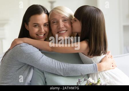 Ritratto di sorridere tre generazioni di donne che si accoccolano insieme Foto Stock