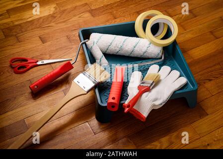 Set di utensili per la verniciatura a casa: Nastro per pittore, guanti, forbici, rulli per pittura e vassoio, spazzola Foto Stock