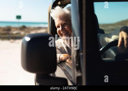 Donna anziana in macchina in spiaggia Foto Stock