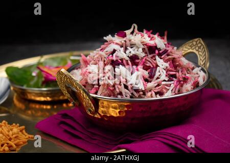 Delizioso pilaf di riso di barbabietola servito in una ciotola tradizionale di rame indiano Foto Stock