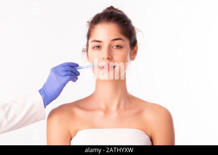 Ritratto di una donna attraente che riceve il trattamento botox per la prevenzione. Isolato su sfondo bianco. Foto Stock