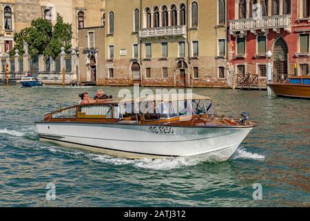 Un taxi d'acqua a Venezia che naviga lungo il Canal Grande, Venezia, Italia Foto Stock