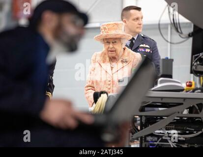 La regina Elisabetta II, con il comandante della stazione James Beck (a destra), guarda l'equipaggio al lavoro su un modello di addestramento F-35B Lightning II combattente durante una visita alla Royal Air Force Marham, Norfolk. Foto Stock