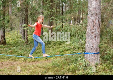 Tween ragazza equilibrio su slackline durante le vacanze estive Foto Stock