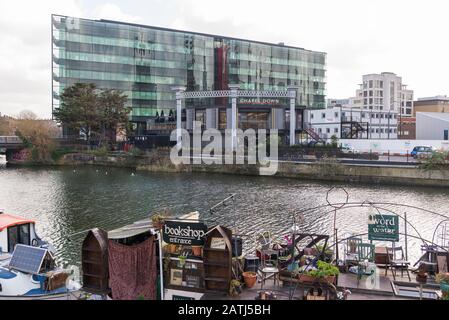 Chapel Down Gin Works, Goods Way, Kings Cross, Londra, Inghilterra, Regno Unito. Word on the Water, la chiatta del libro di Londra, è ormeggiata lato canale in primo piano. Foto Stock