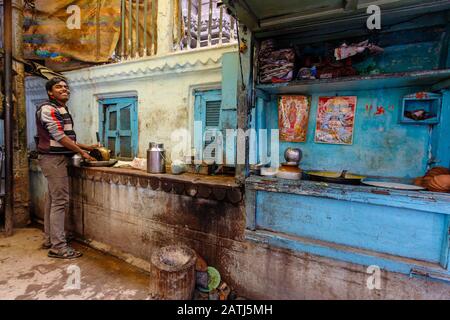 Varanasi, INDIA, 19 GENNAIO 2019 : uno chef indiano lavora nella sua colorata cucina all'aperto in una strada stretta di Varanasi. Foto Stock