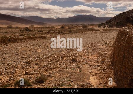 il deserto nel sud del marocco, una catena montuosa dietro una valle Foto Stock