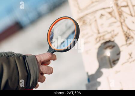 Lente d'ingrandimento che brucia l'immagine. Loupe in mano e il sole. Foto Stock