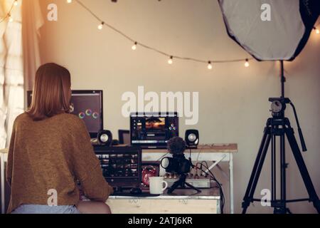 Un editore freelance femminile che lavora editing video filmati con il laptop in casa studio questo è lo stile di vita di blogger o creatori di contenuti freelance Foto Stock