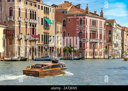 Un taxi d'acqua con passeggeri fa il suo percorso lungo il Canal Grande a Venezia, Italia Foto Stock