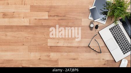 Tavolo da ufficio in legno con computer portatile e forniture. Scrivania con vista dall'alto e spazio per le copie. Foto Stock