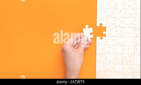 Mano mettere l'ultimo pezzo di puzzle. Completare la missione. Concetto di business. Foto Stock