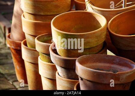 Vasi di argilla arancione al sole. Preparazione per il giardinaggio domestico della molla. Coltivazione di piante organiche. Foto Stock