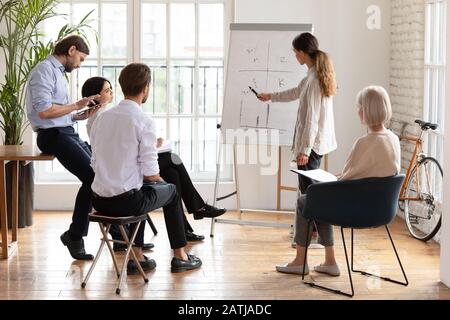 L'altoparlante femminile presenta la lavagna a fogli mobili per i colleghi Foto Stock