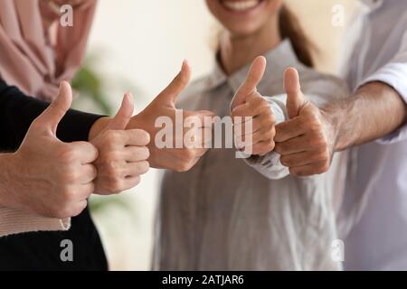 Primo piano di colleghi multiculturali mostrano i pollici Foto Stock