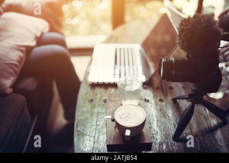 Il Vlogger nella caffetteria dello studio o casa studio godendo con le riprese nel laptop Foto Stock