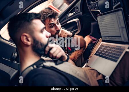 Diagnostica vettura.Meccanica con computer portatile in auto presso il garage di riparazione. Foto Stock