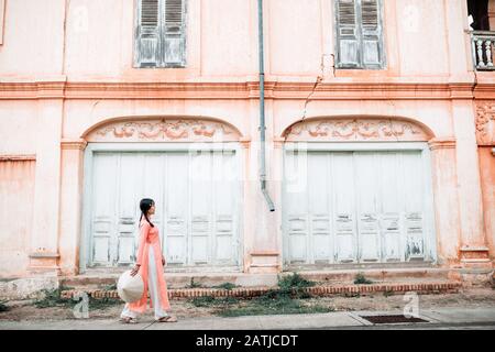 Giovane donna che indossa un abito Ao dai Visita lo storico stile francese. Nella Provincia Di Sakon Nakhon, Thailandia Foto Stock